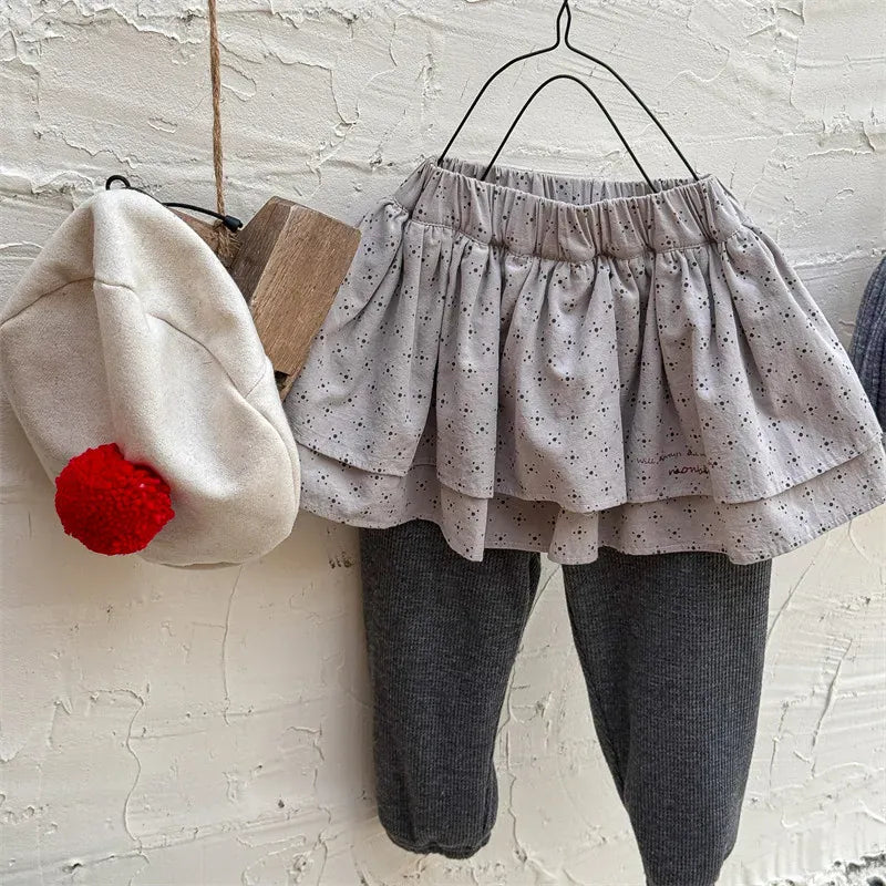 スカッツ、薄いグレーのティアードスカート風トップとチャコールのレギンス