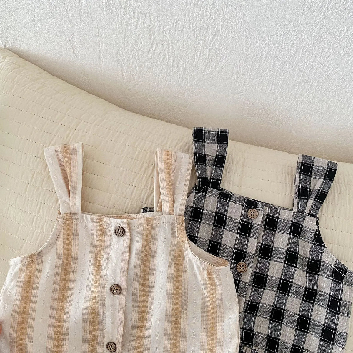ベージュのブラウスと黒白チェックのワイドパンツ、ストラップ&ボタン部アップ