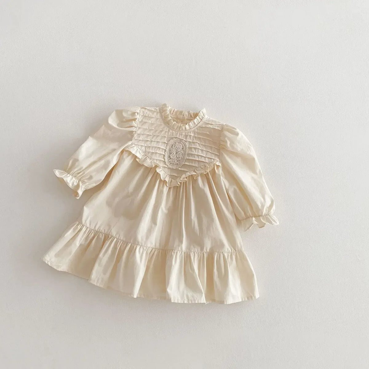 アイボリーのキッズワンピース、刺繍入りフリルとパフスリーブ長袖