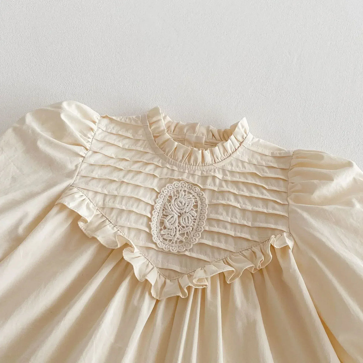 キッズ用オフホワイト長袖ワンピース、胸元の刺繍レースとギャザーフリル