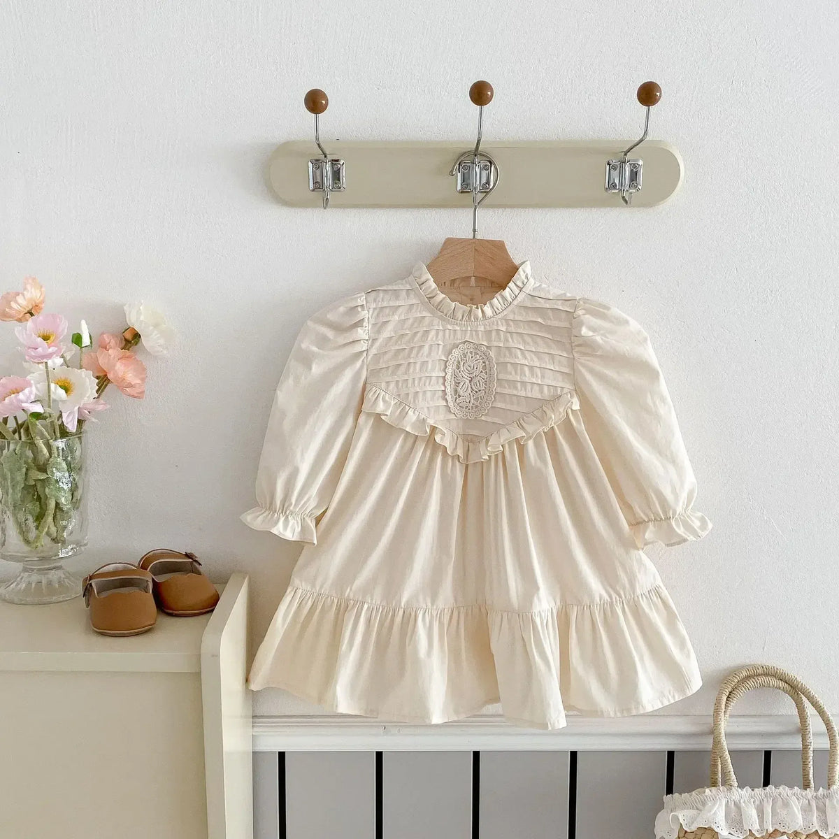 キッズ用クリーム色ワンピース、長袖パフスリーブと刺繍フリルのフレアシルエット