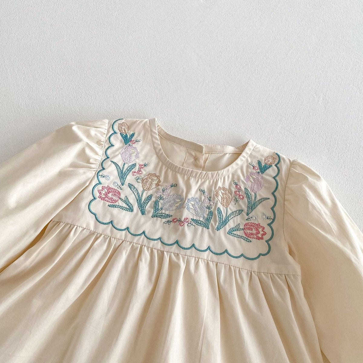 生成りのフラワー刺繍入りフリル長袖ドレス(胸元アップ)