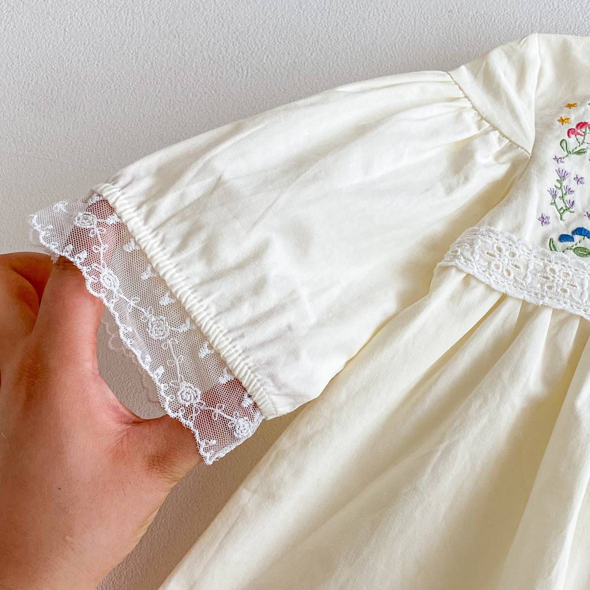 生成り長袖ワンピースの袖口アップ、レースフリルと花刺繍の一部