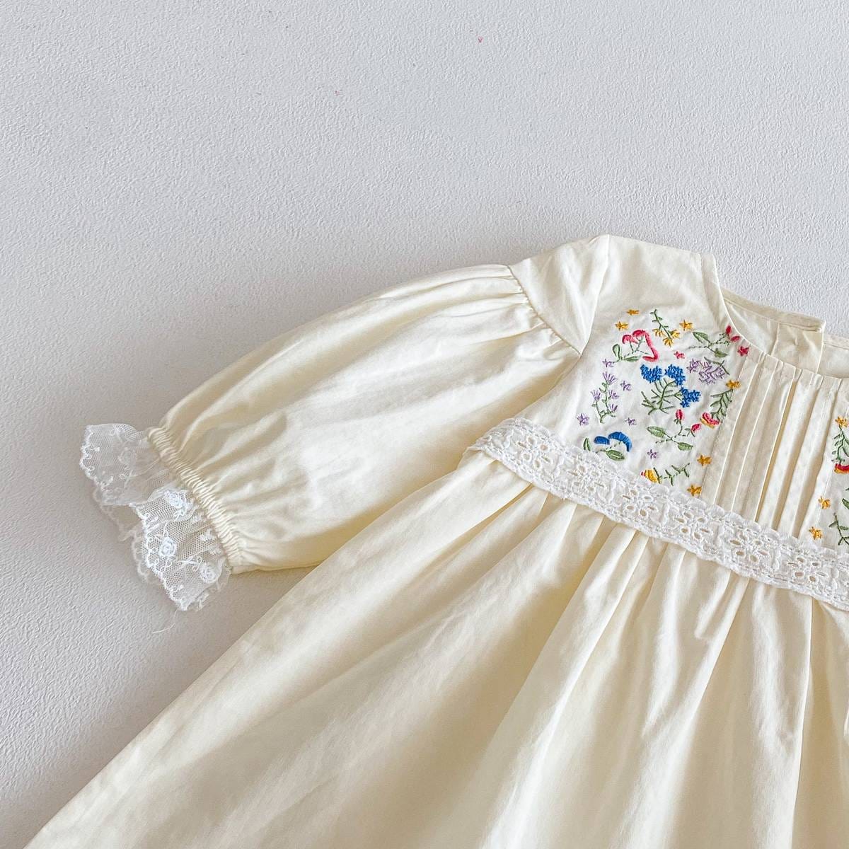 長袖ワンピースの花柄刺繍パネルとレース帯。クリーム色、ふんわり袖