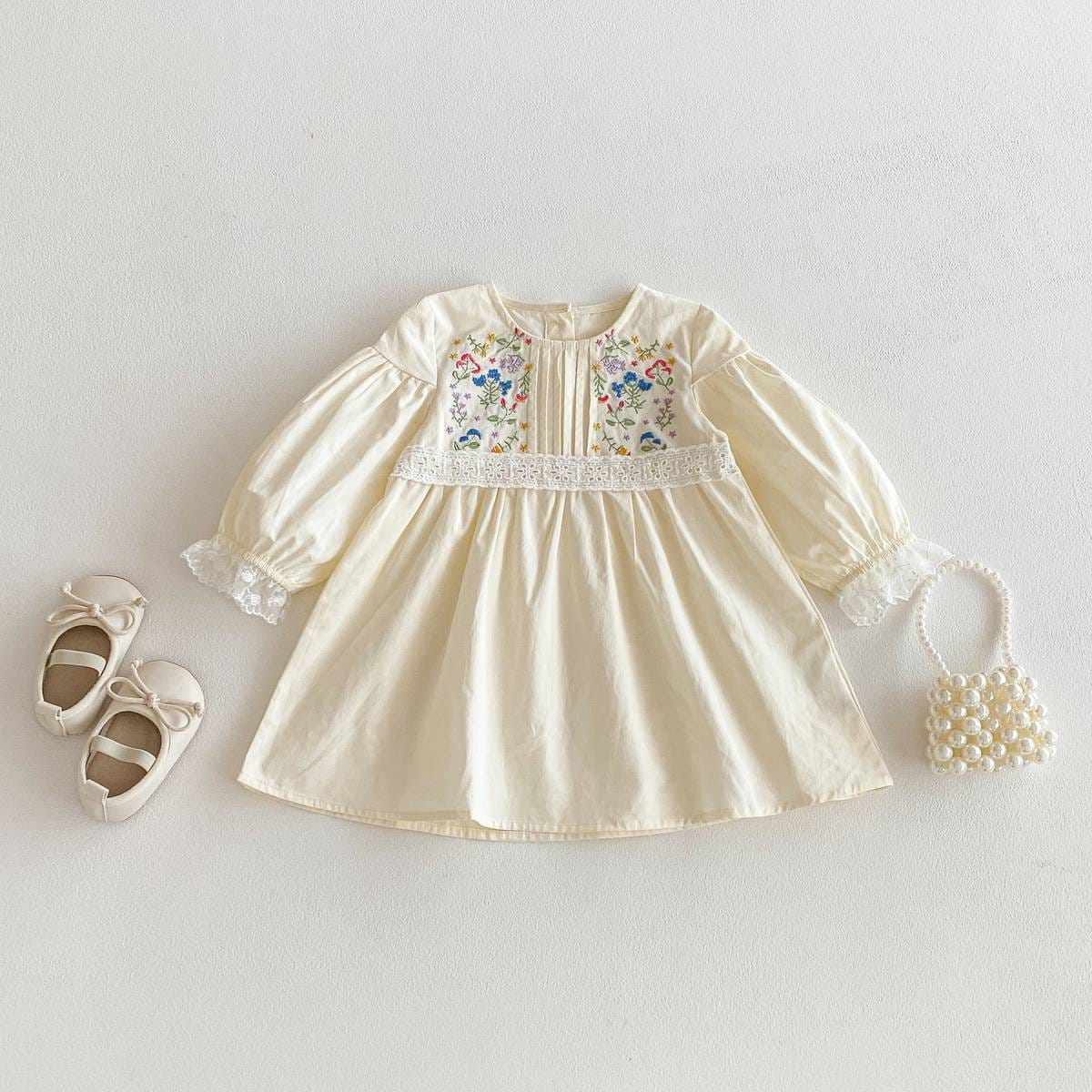 長袖ワンピース(膝丈目安)。クリーム色、花柄刺繍パネル付きのフレアシルエット