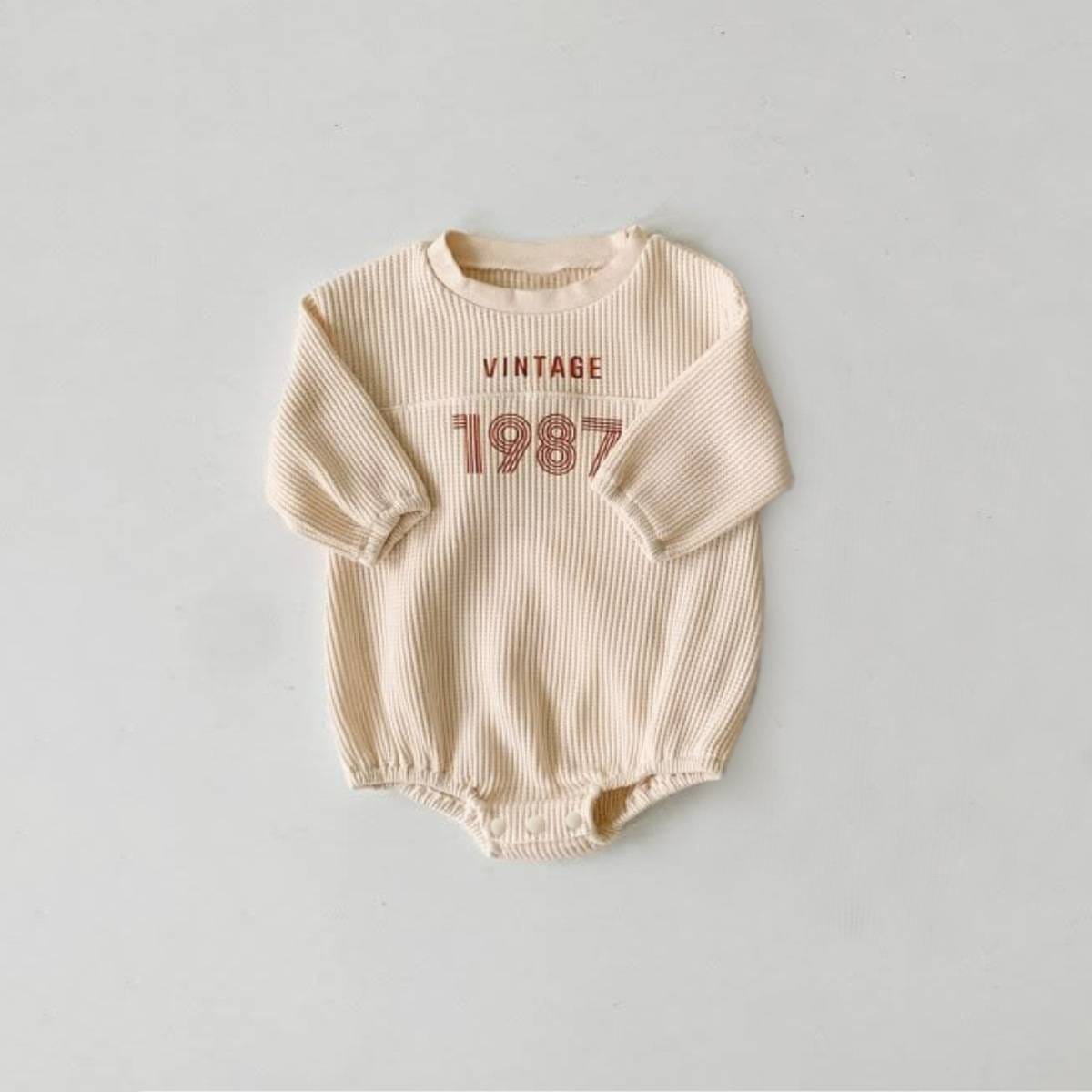 ベージュ系長袖ワッフル素材ロンパース、VINTAGE「1987」ロゴプリント