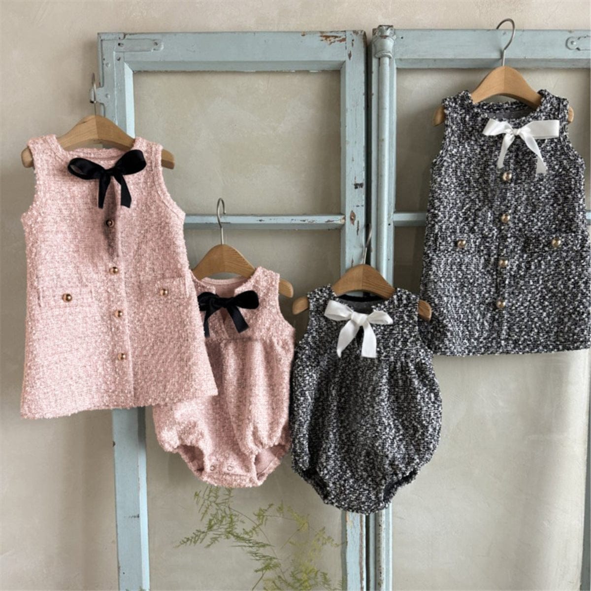 ピンクと黒×白ミックス柄のフロントリボン付きノースリーブロンパース