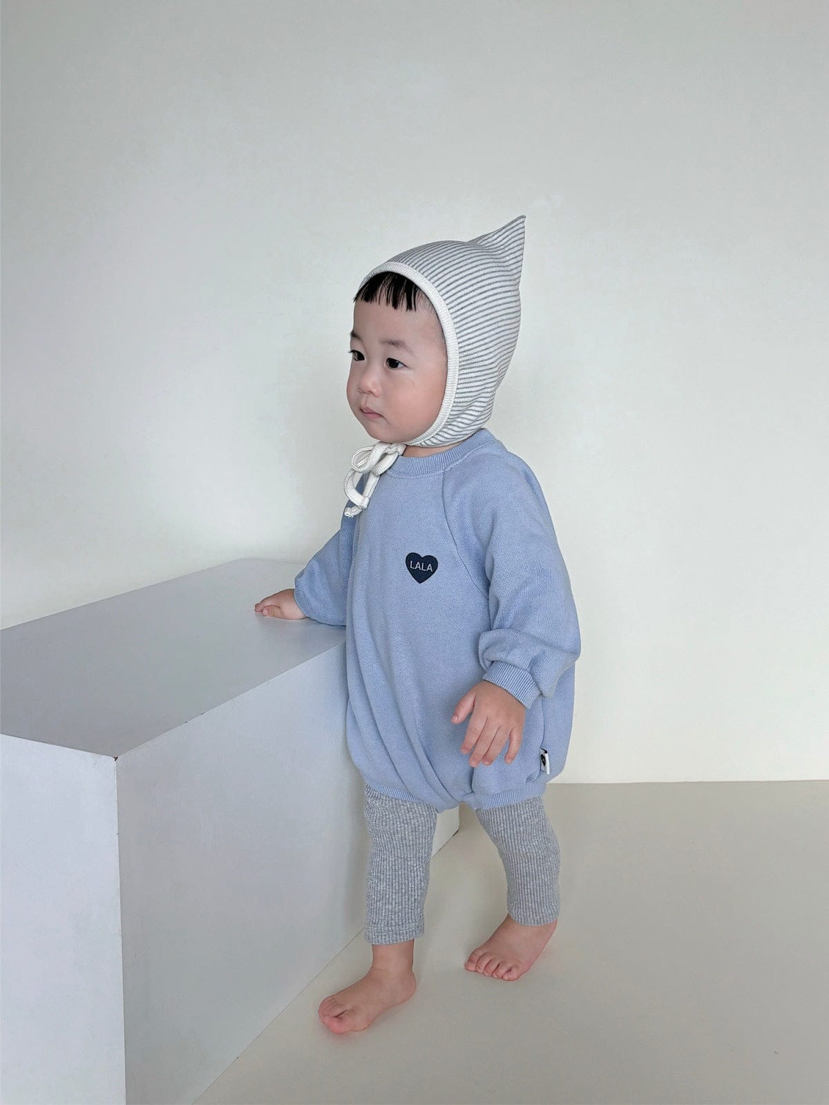 ハート刺繍入りブルーのスウェットロンパース、ラグラン袖・ストライプフードと結び紐