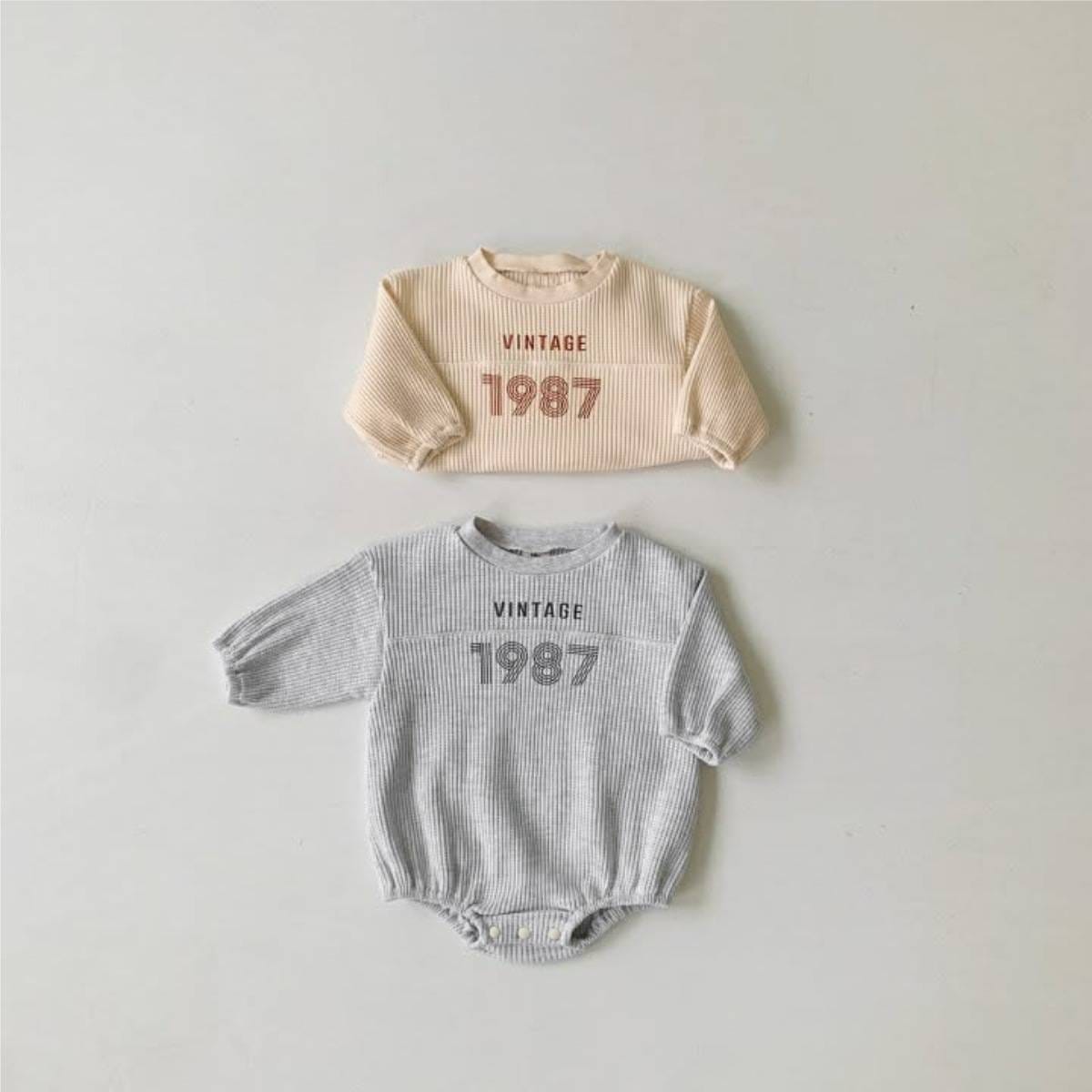 ベージュとライトグレーの長袖ワッフル素材ロンパース、VINTAGE「1987」プリント