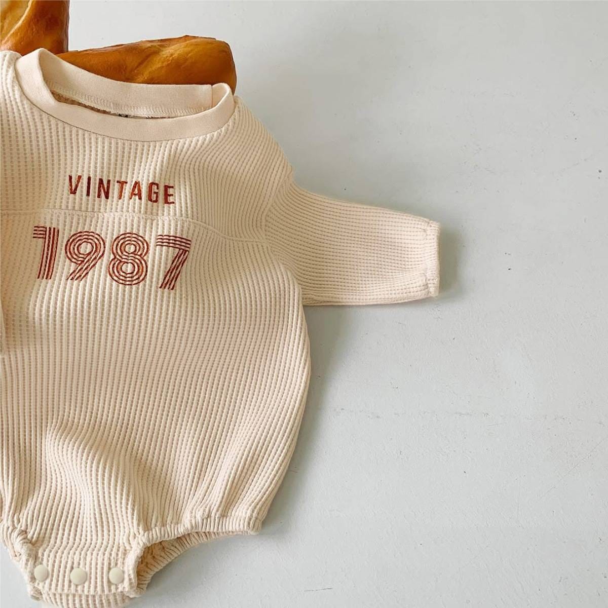 ベージュ系長袖ワッフル素材ロンパース、VINTAGE「1987」ロゴプリント