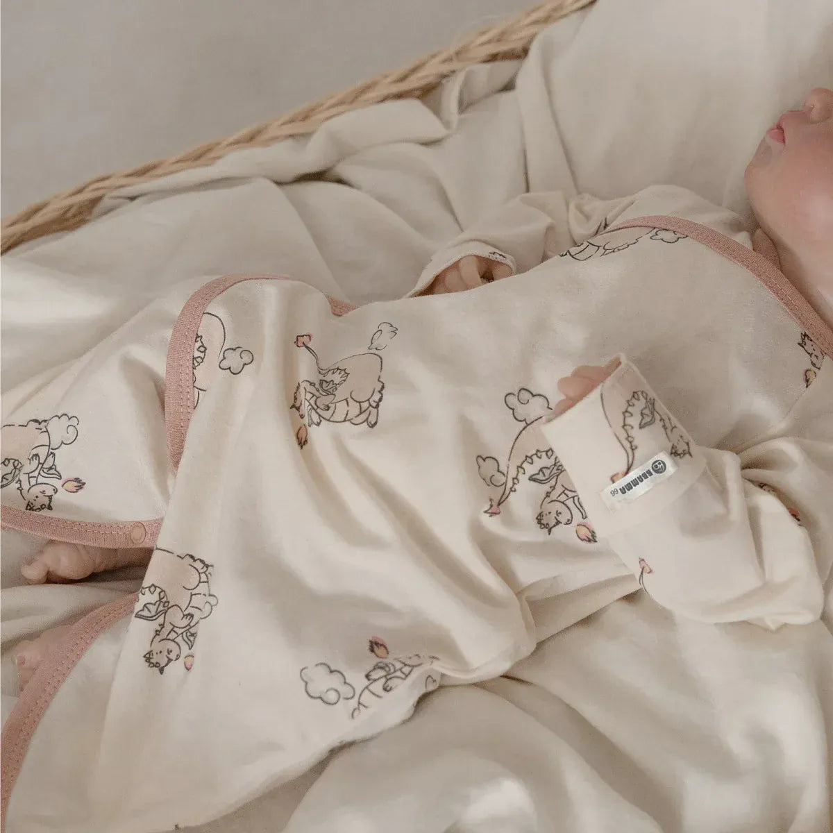 とんがり帽子付きベビー用ロンパース、動物プリントのクリーム地ピンクフチ