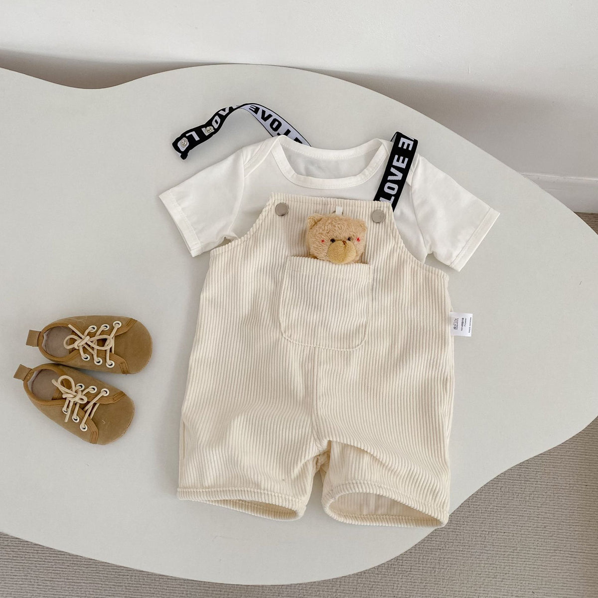 コーデュロイのサロペット風ハーフパンツ(ミルク白)くまワッペンと前ポケット、ロゴ吊りひも