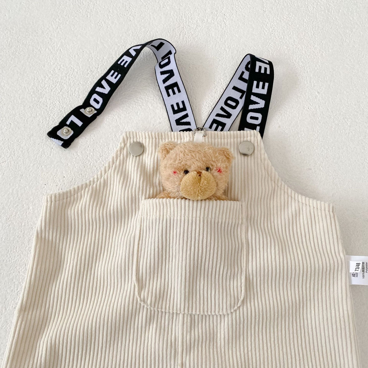 コーデュロイのサロペットショートパンツ、前面にくま付きポケット