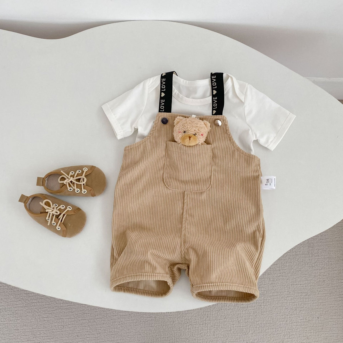 コーデュロイのサスペンダー付きショートパンツ(カーキ)前面、くまモチーフ付