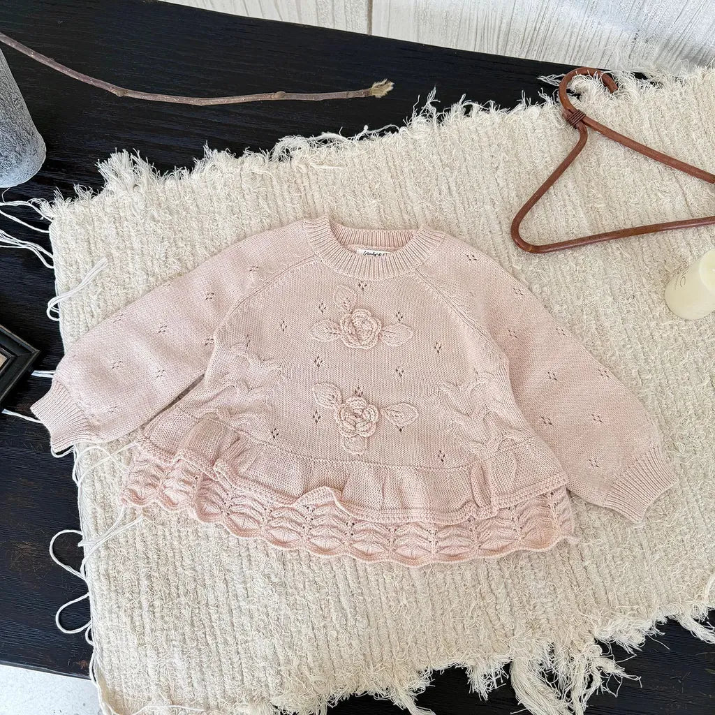 淡いピンクの花刺繍フリルニット、丸みのある裾と段フリル