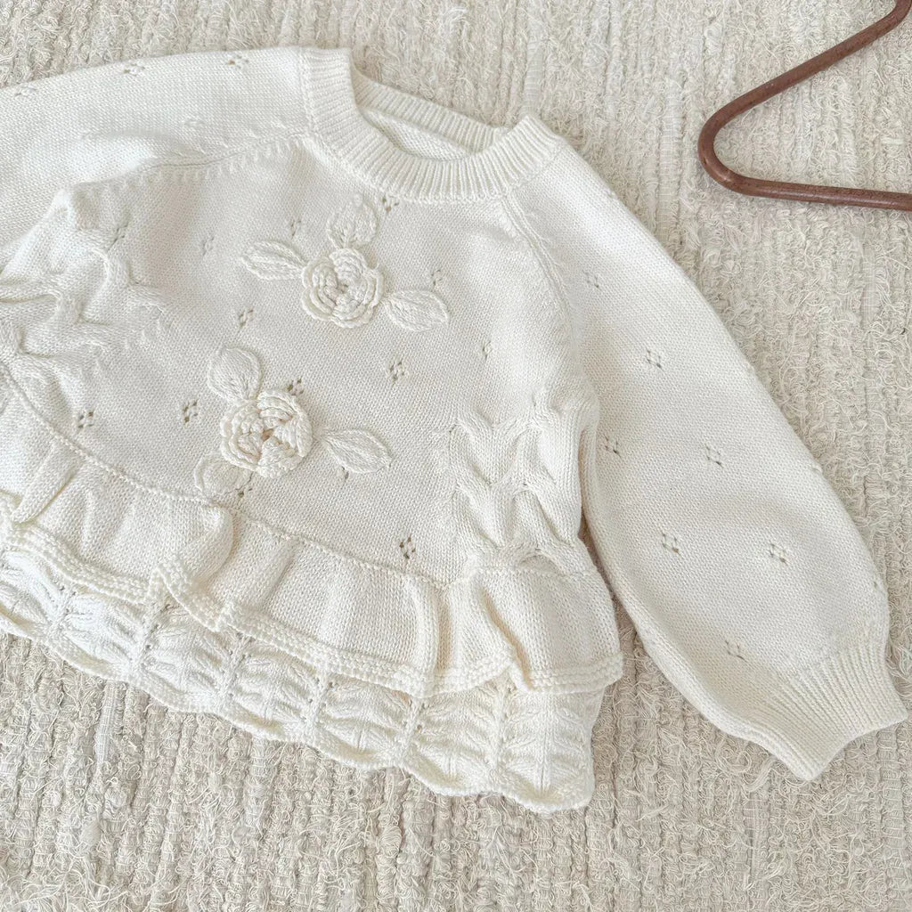 クリームホワイトのニットプルオーバー、フラワー刺繍とフリル切替の長袖