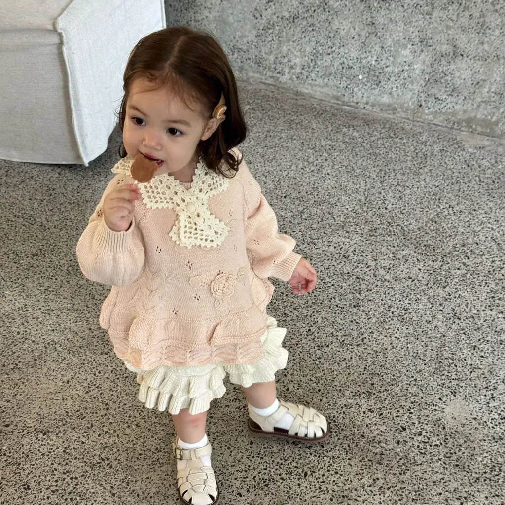 淡いピンク花刺繍ニット、胸のモチーフと裾の段フリル
