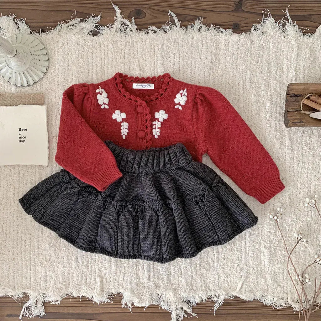 赤のフラワー刺繍ニットフリルカーディガンと黒のサスペンダースカート