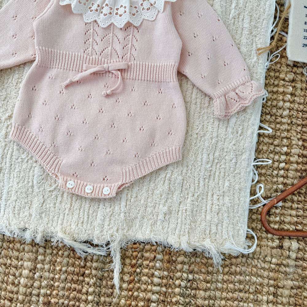 ピンク長袖ニットロンパースの裾アップ、前ボタンとリブ編み