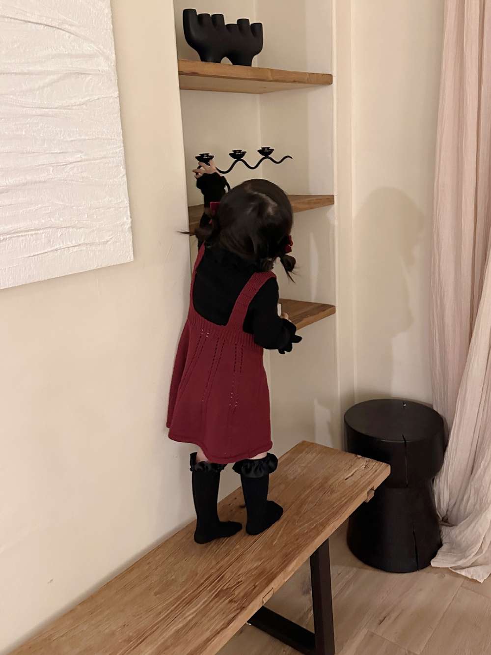 黒の長袖ニット、ラッフル風フリルネックの後ろ姿。