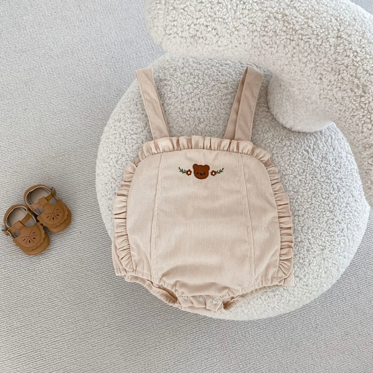 ベージュのサスペンダーブルマー、胸のくま刺繍とフリル