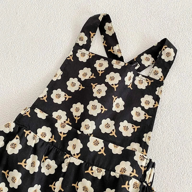 黒い花柄のサロペット。肩ひも付き、ウエストギャザーとふんわりシルエット