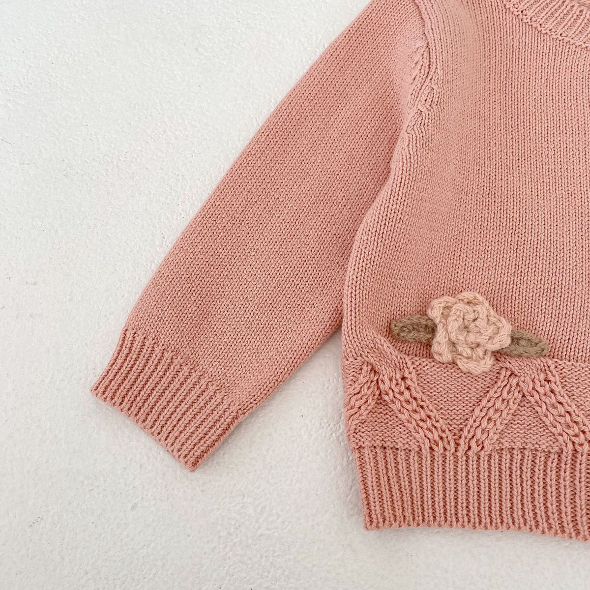 パールピンクのニットカーディガン袖。花刺繍の飾り付き切替と編み目