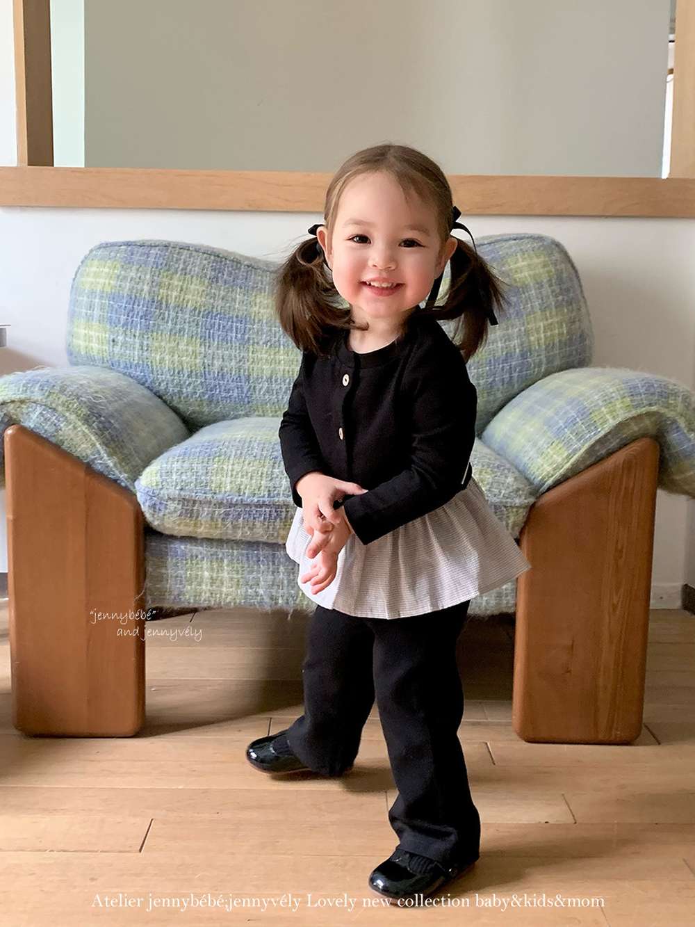 子ども用セットアップ:黒カーディガンの前ボタンとペプラム、ワイドパンツ姿