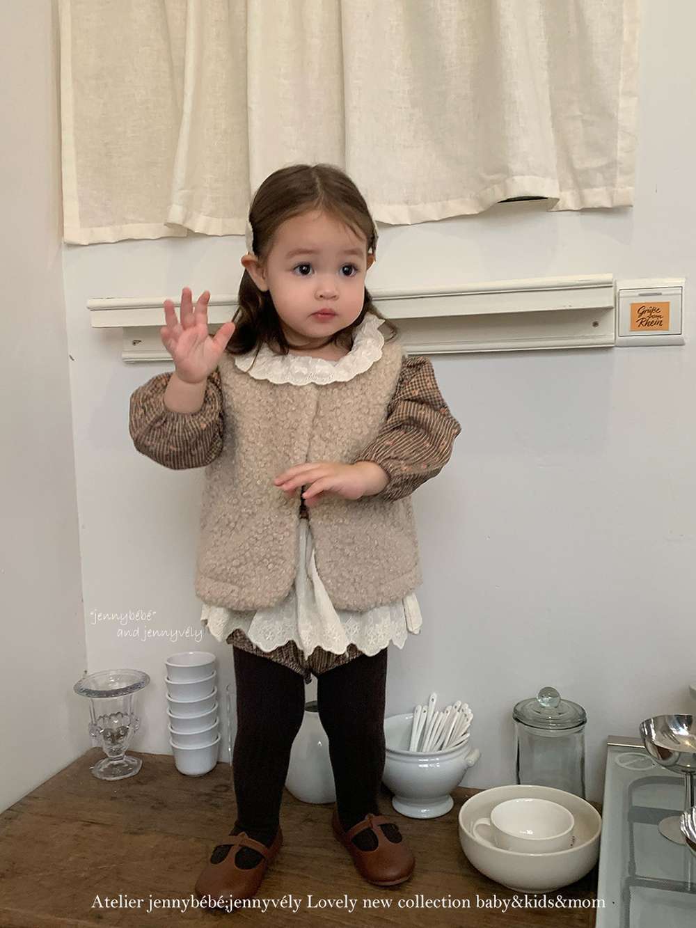ベージュのもこもこベスト風トップスと黒タイツ、子ども用セット