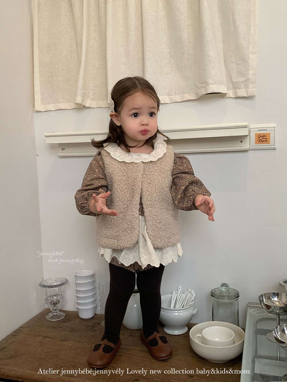 ベージュのもこもこベスト風トップスと黒タイツ、子ども用セット
