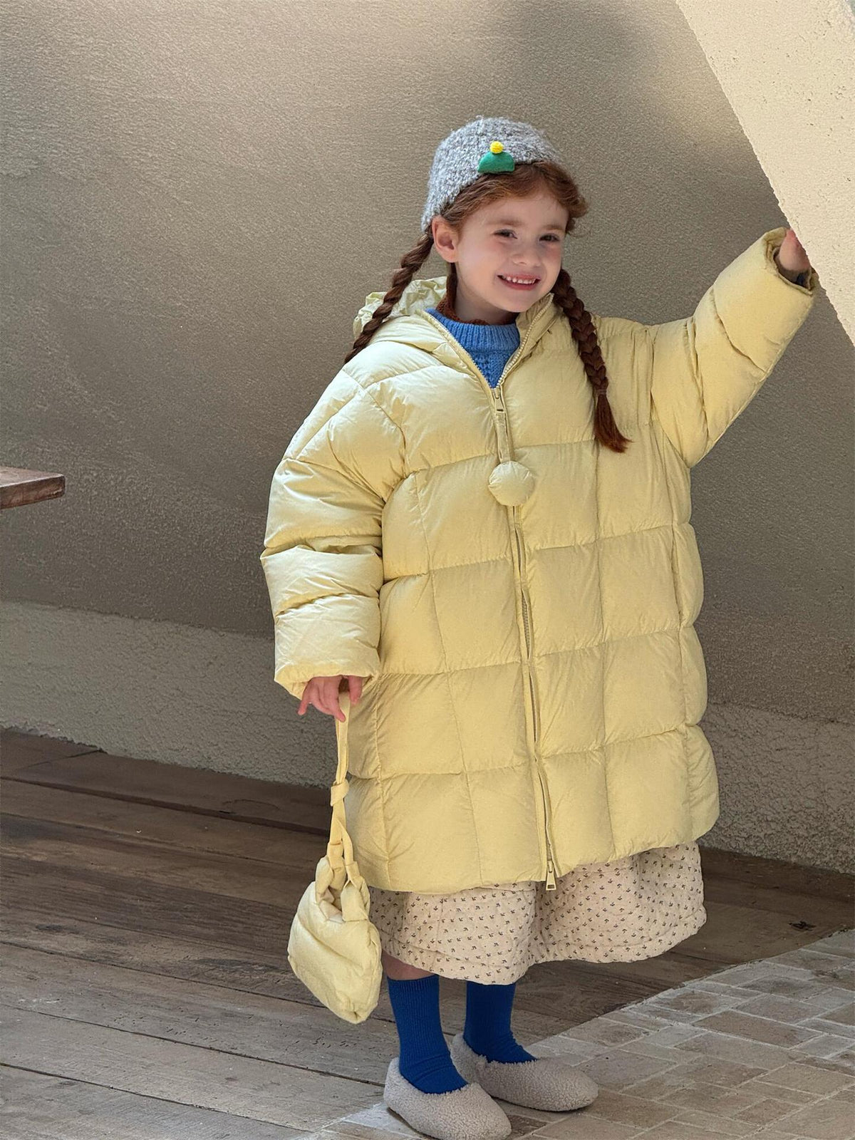 フード付きイエローダウンコートの子ども、フロントジッパーが見える