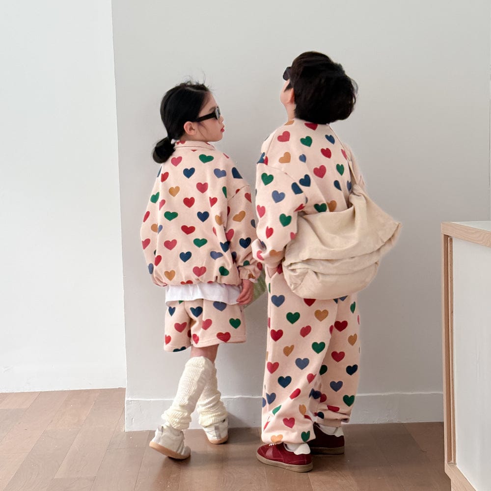 カラフルハートプリントのキッズ上下セット、ベージュ地の上着とボトム(後ろ)