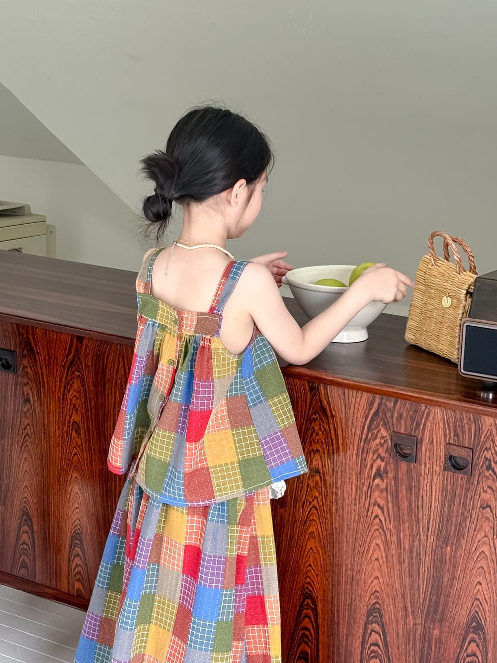 マドラスチェック柄の子ども用スカート、背面のノースリーブトップとフリルヘム