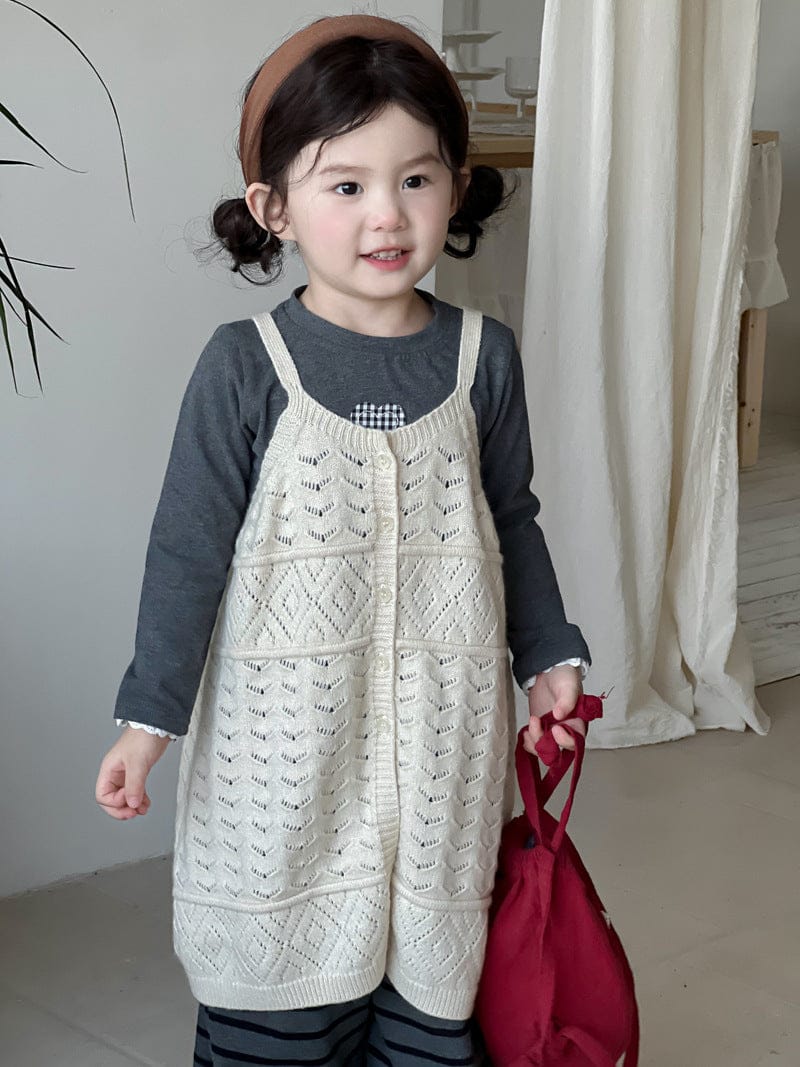 生成りニットビブベストとボーダー柄ロングパンツ(正面寄り)
