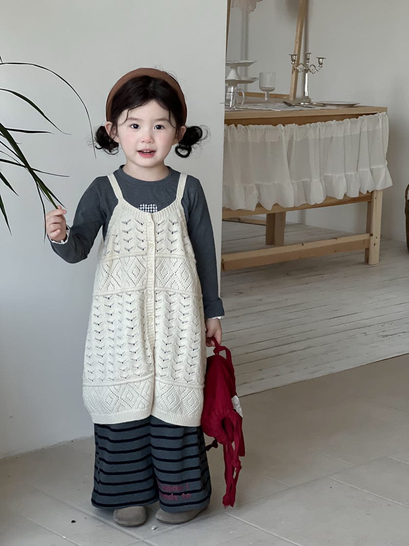 ボーダー柄ロングパンツと生成りニットビブベスト、赤い巾着付き