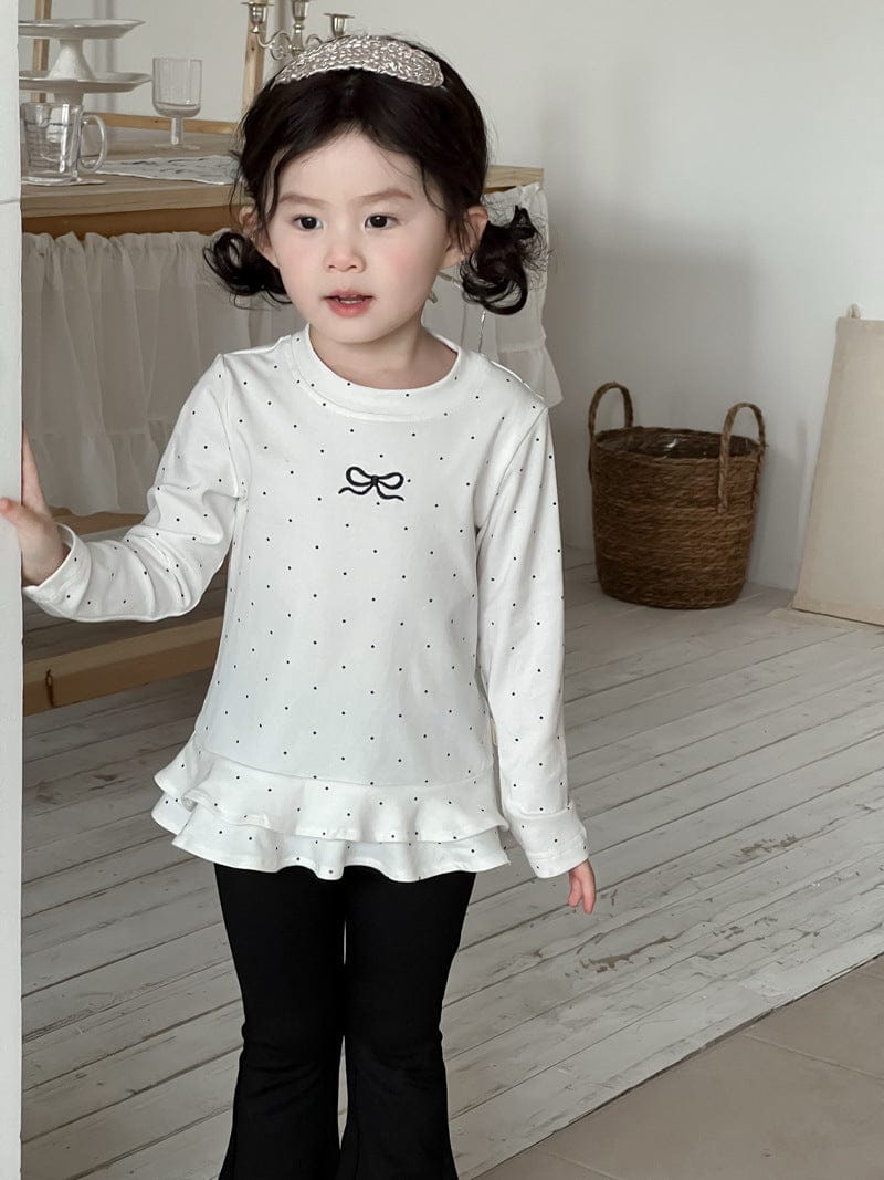 白のリボン刺しゅうドット柄長袖Tシャツ、裾フリル付き黒フレアパンツ