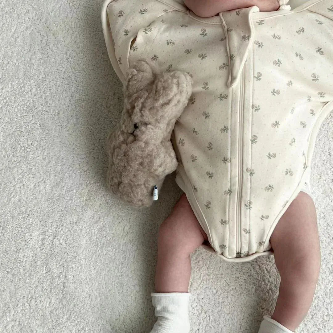 恐竜柄のベビー用スリーパー、前開きジッパー。添い寝中の赤ちゃん