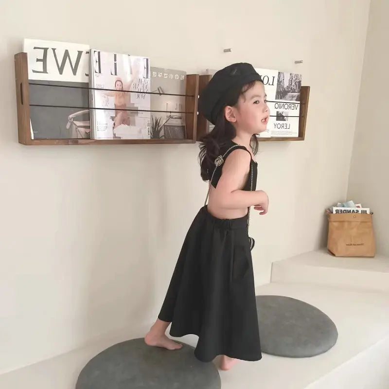 子ども用黒のノースリーブワンピース、横向きで見える背中オープン