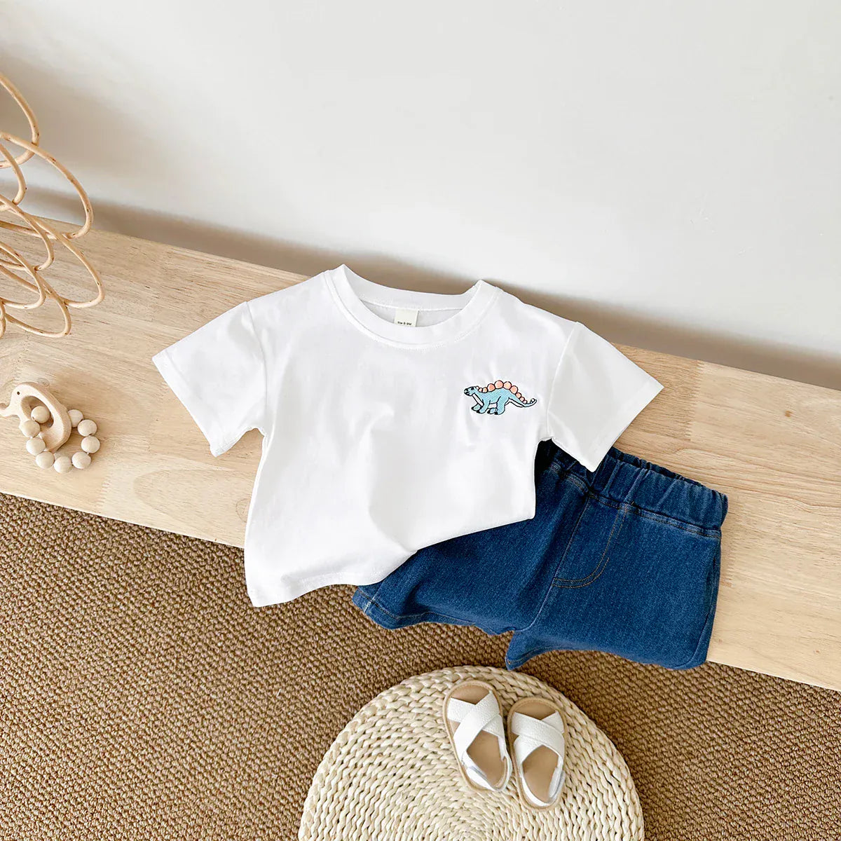 恐竜刺繍の白い半袖Tシャツと青いデニムショートパンツ(2点セット)