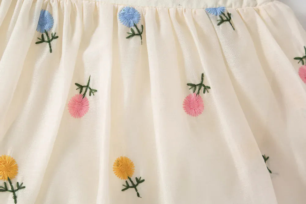 白地にカラフルな花柄刺繍のスカート風フレア部分