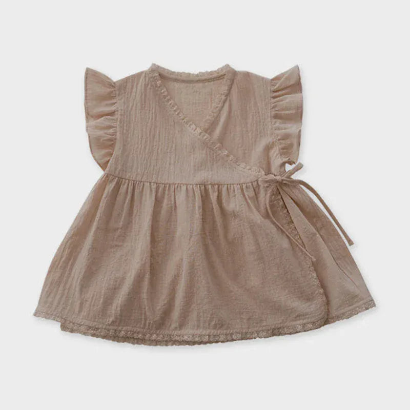 ベージュのキッズ用ラップチュニックブラウス、フリル袖とリボン飾り