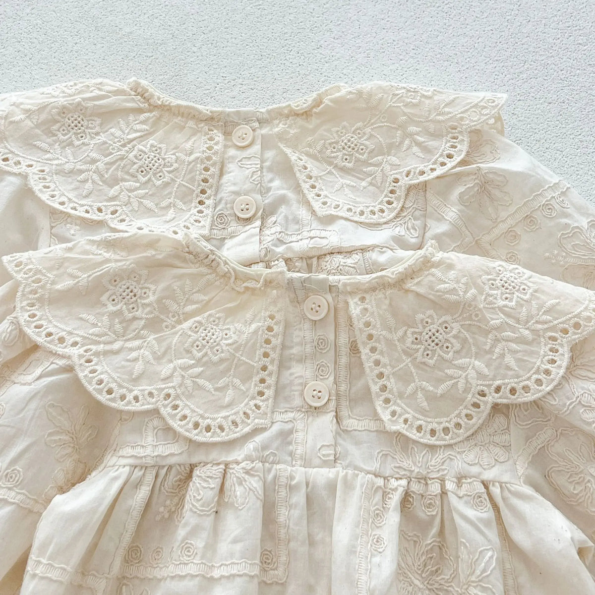 白いレース刺繍の長袖ベビー服、前ボタンとビッグカラー