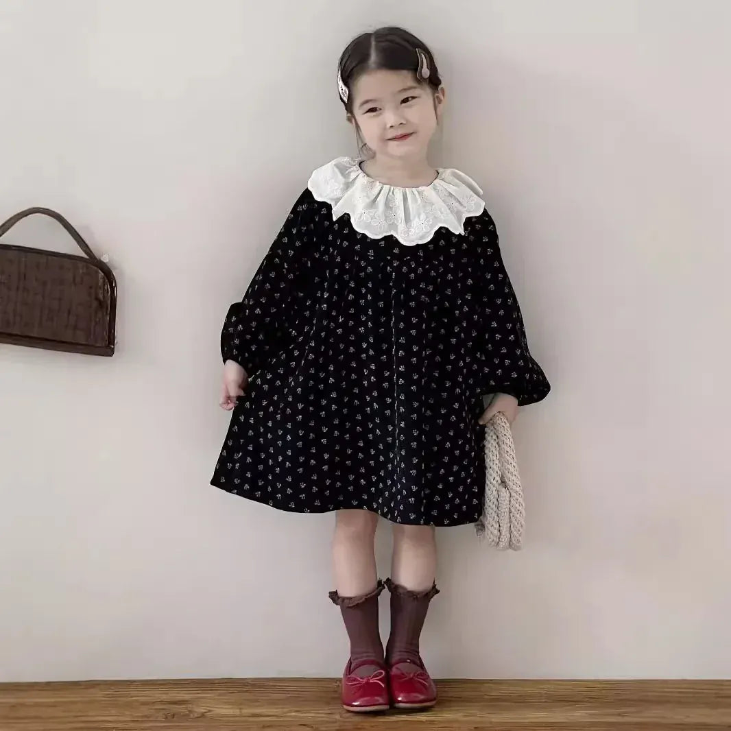 小花プリントの黒キッズワンピース、白フリル襟とドルマンスリーブ風