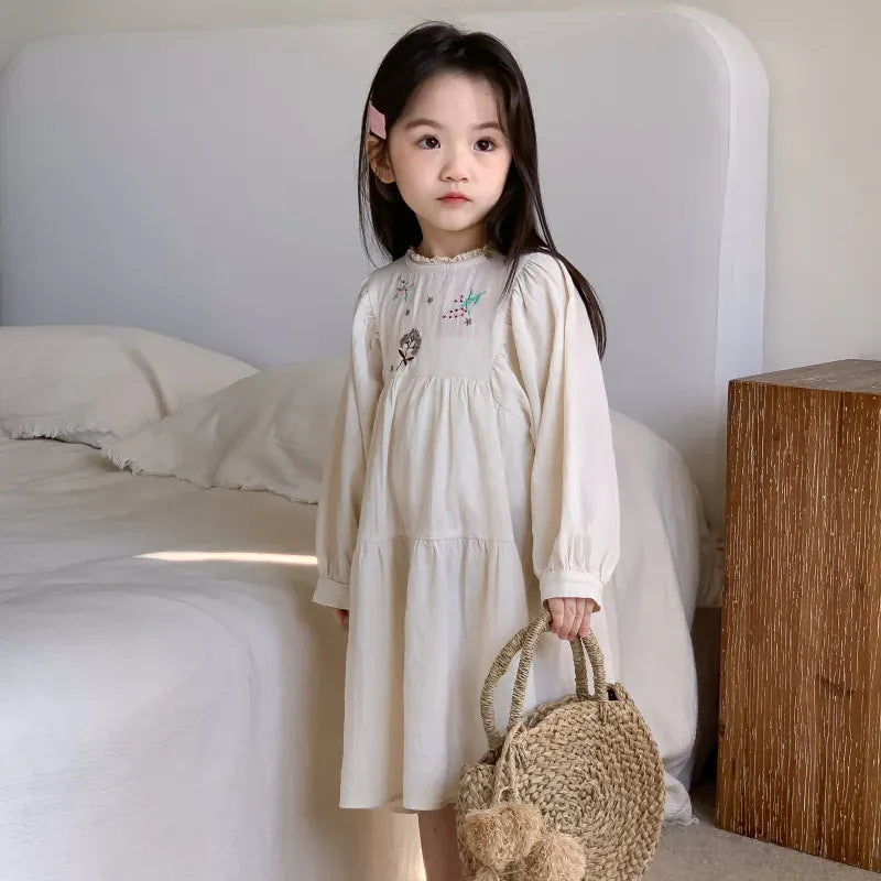 生成りのキッズワンピース、刺繍入りのラウンドネックでふんわりシルエット