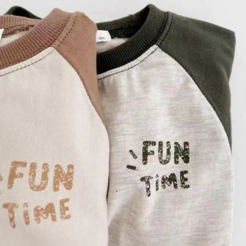 ラグラン長袖ジャンプスーツの配色切替、首リブと「FUN TIME」フロントプリント