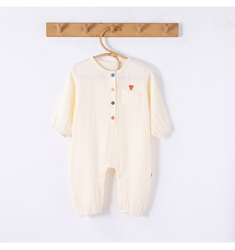 生成り色のワンポイント刺繍入り長袖ロンパース、前開きボタンと胸ポケット