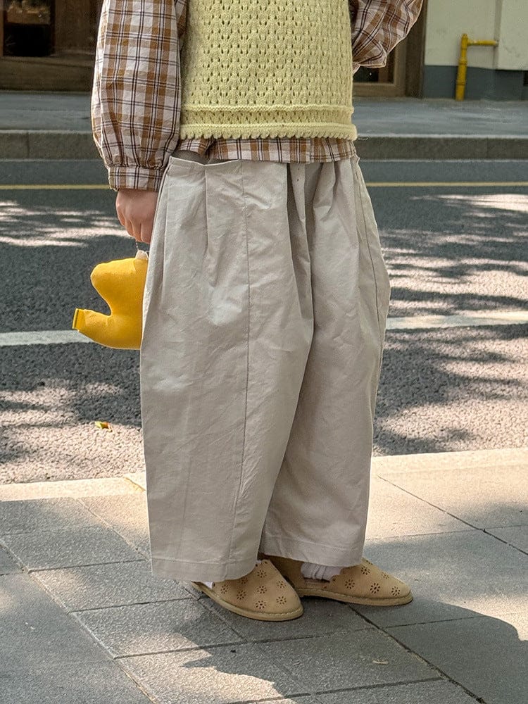 ベージュ系のゆったりコクーンパンツ、センターの縦折りとたっぷりシルエット