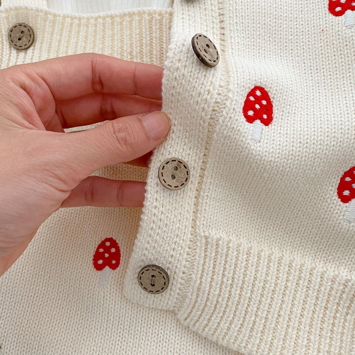 ベビー用ニットカーディガン風ロンパース、前立てのボタンと赤いきのこ刺繍