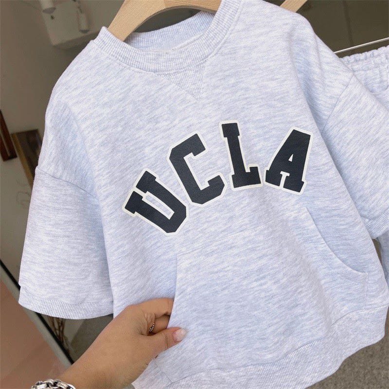 キッズ用半袖スウェットトップ、黒のUCLAロゴが目立つライトグレー系