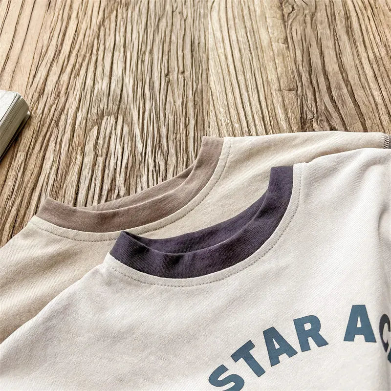 キッズ用バイカラー長袖Tシャツの胸元アップ、ロゴプリント入りラグラン袖